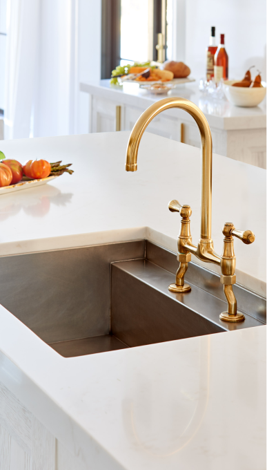 White marble countertop and golden faucet by the sink