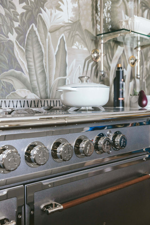 Silver French kitchen ranges with silver burner and green printed wallpaper