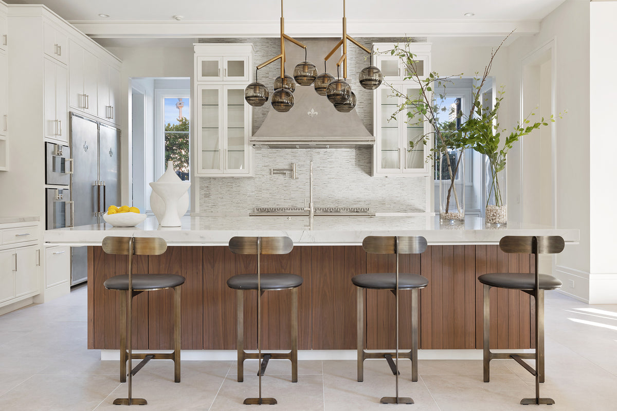 Wooden Base Kitchen Cabinets With Marble Countertop In the middle of the Kitchen. Silver Luxury Kitchen Range Hood in between White Wall Cabinets