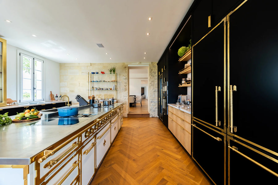 Luxury French Kitchen Range island in white with matte black refrigerators.