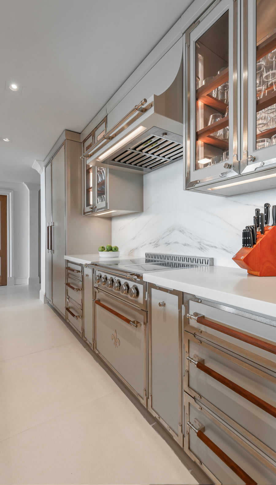 Custom high-end kitchen pantry storage featuring integrated cabinetry with built-in door-mounted spice racks for pantry organization.