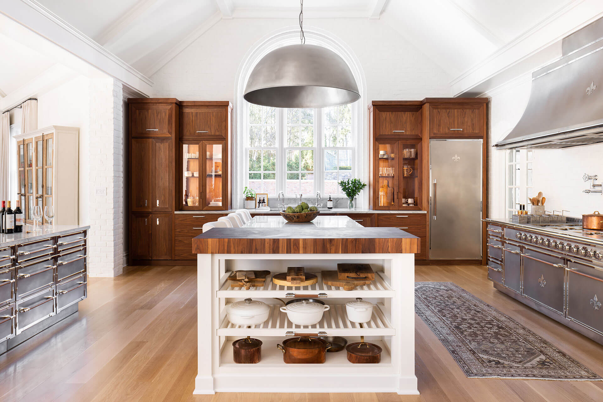White Widows in between Wooden Kitchen Cabinets, Silver French Kitchen Ranges and Kitchen Hood
