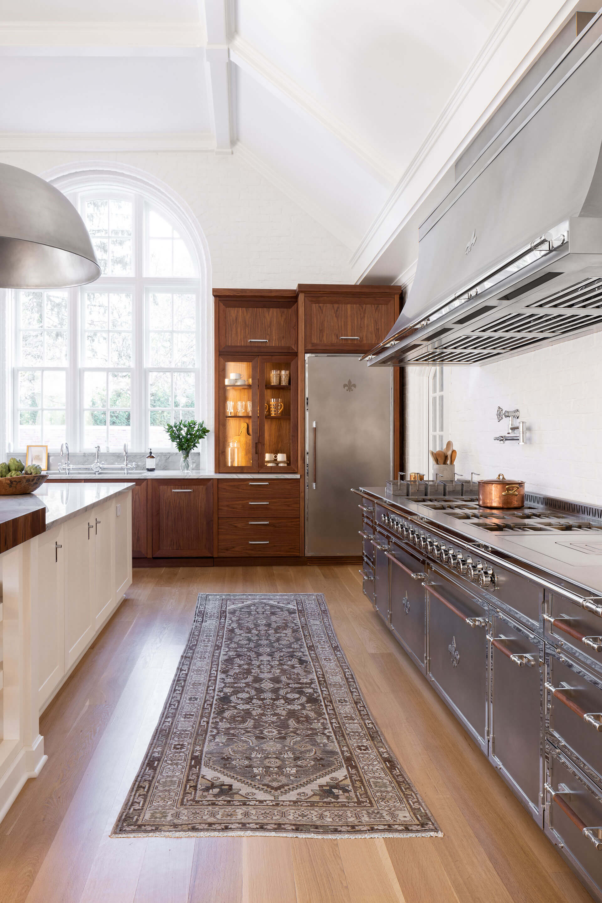 Silver French Kitchen Range with burners, stoves and a hood, rug on the wooden Flooring