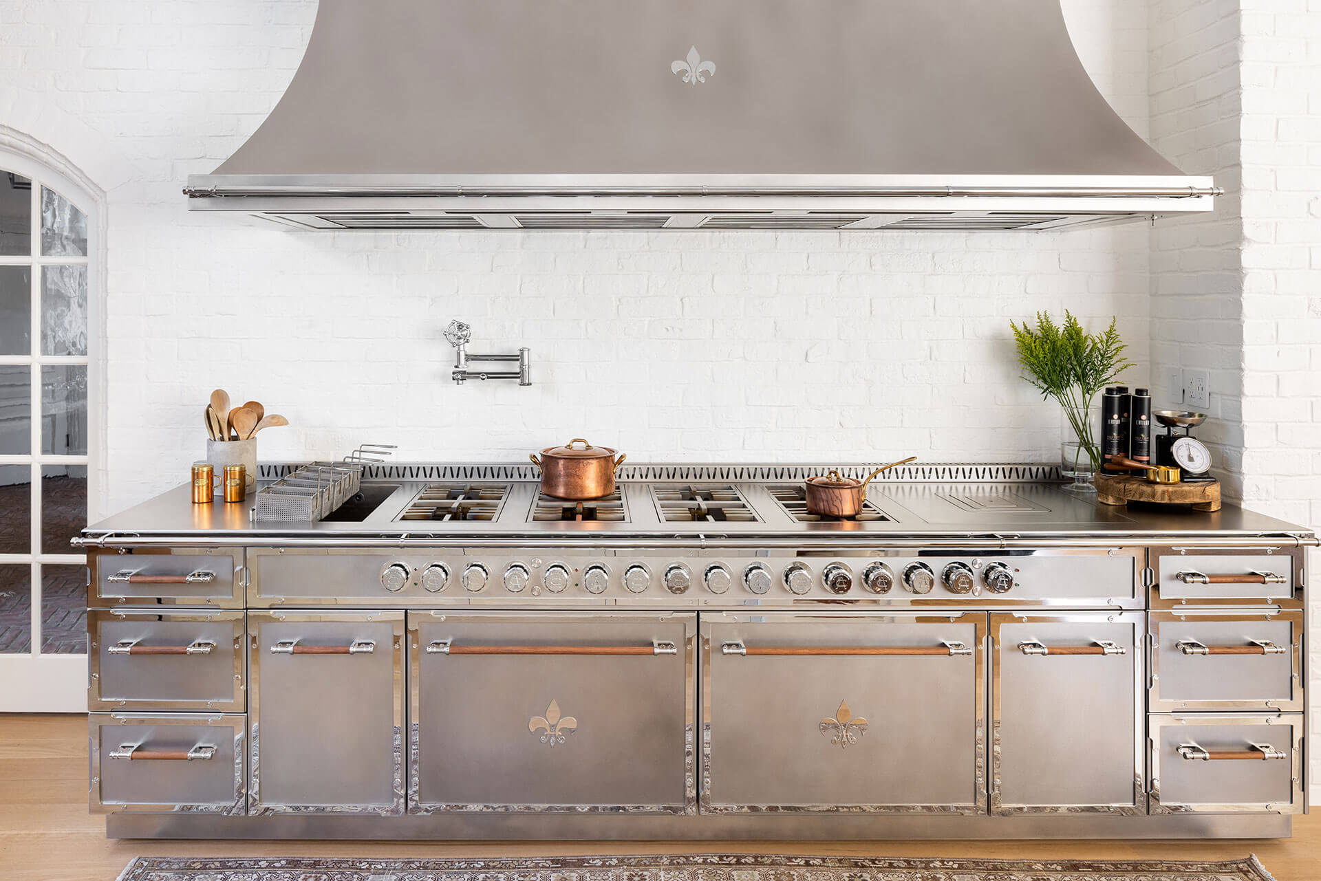 Silver Custom French Kitchen Range With Hood and Copperware on a stove