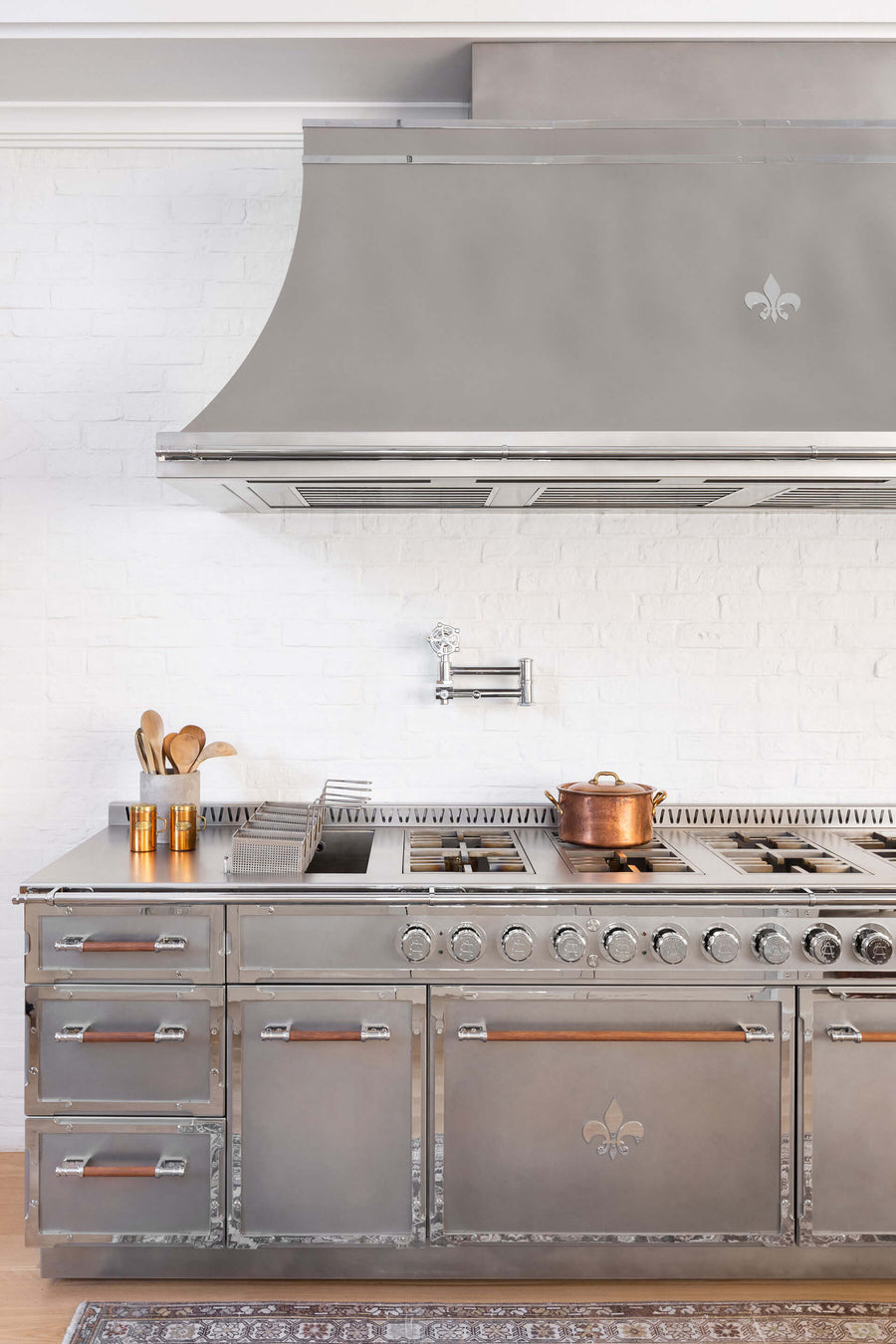 Silver Custom French Kitchen Range With Hood and Copperware on a stove