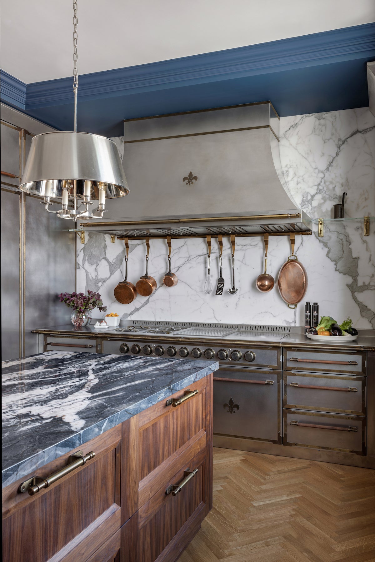 Modern French-style kitchen with built-in white and brass appliances, dual wall ovens, wine cooler, and light wood cabinetry.