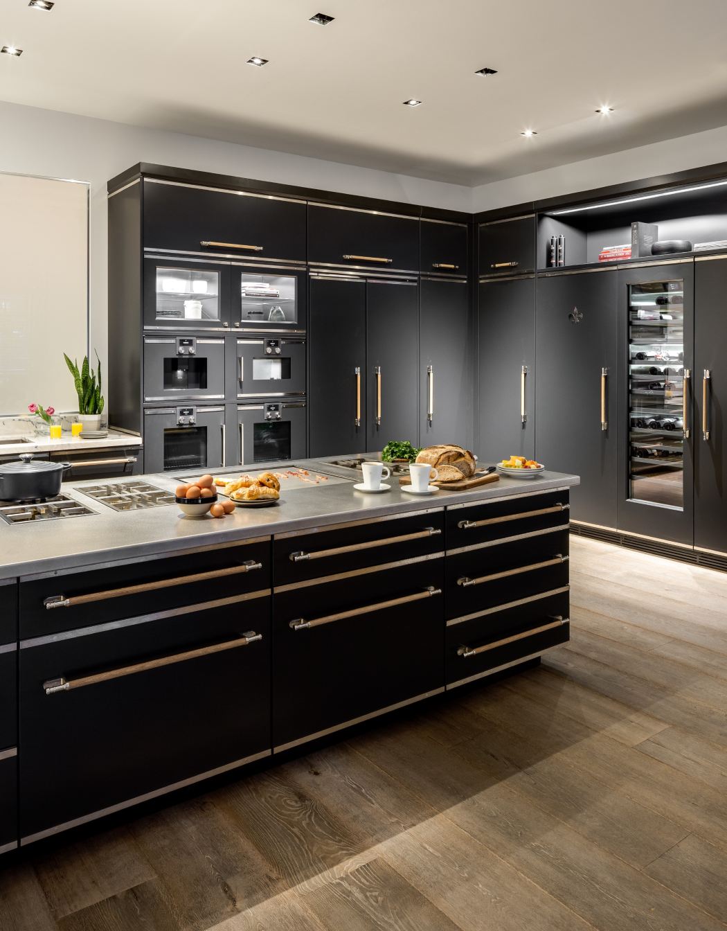 Black kitchen cupboards with wall mounted French ovens with black kitchen cabinets below kitchen countertops with inbuilt stove