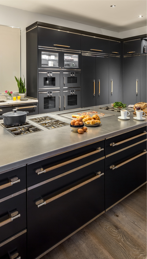 Black kitchen cupboards with wall mounted French ovens with black kitchen cabinets below kitchen countertops with inbuilt stove