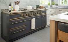 Black color kitchen cabinet with golden burners and black oven door