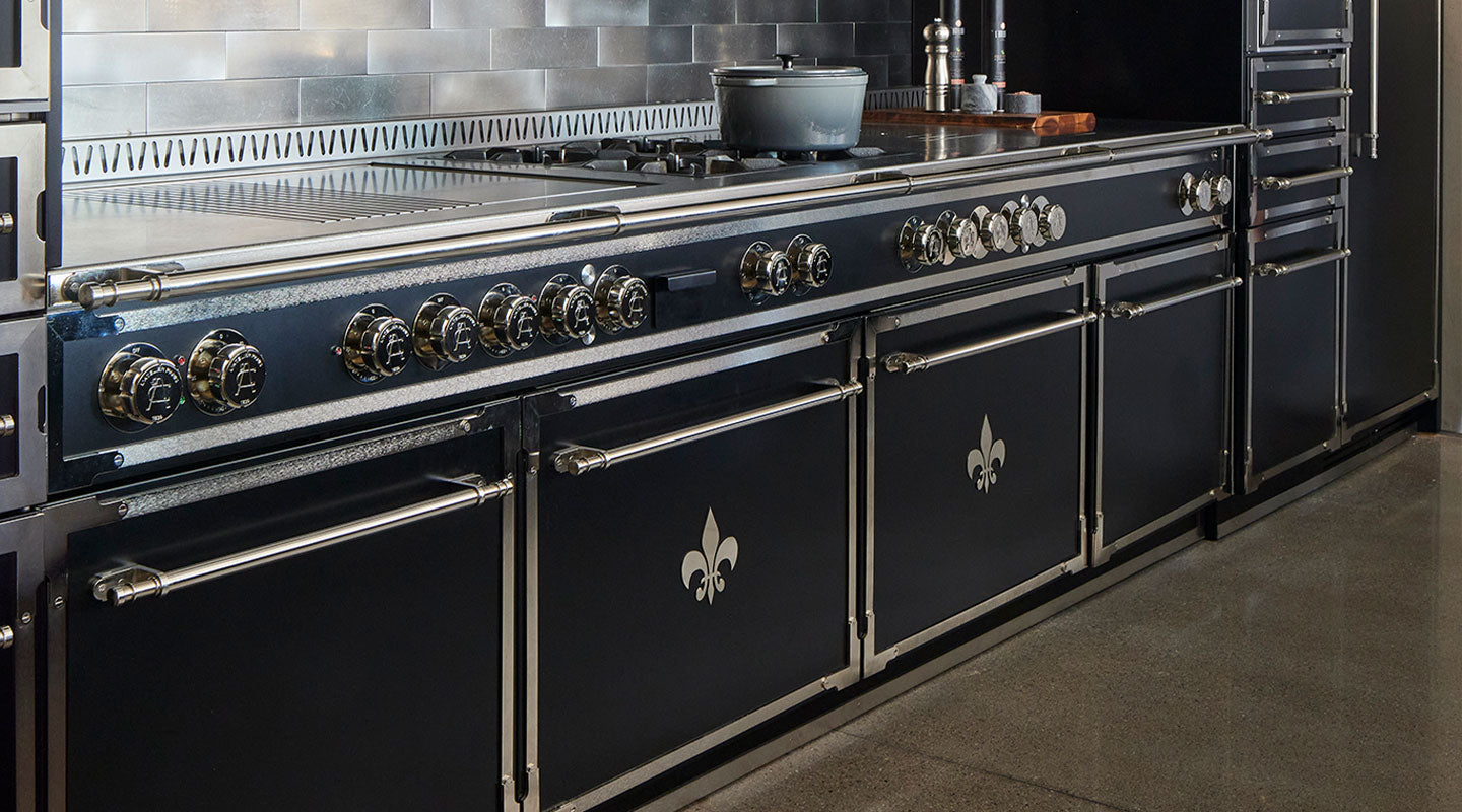 Matt Black Kitchen Cabinets With an Oven, Silver Handles & Burners and cookware on a gas stove