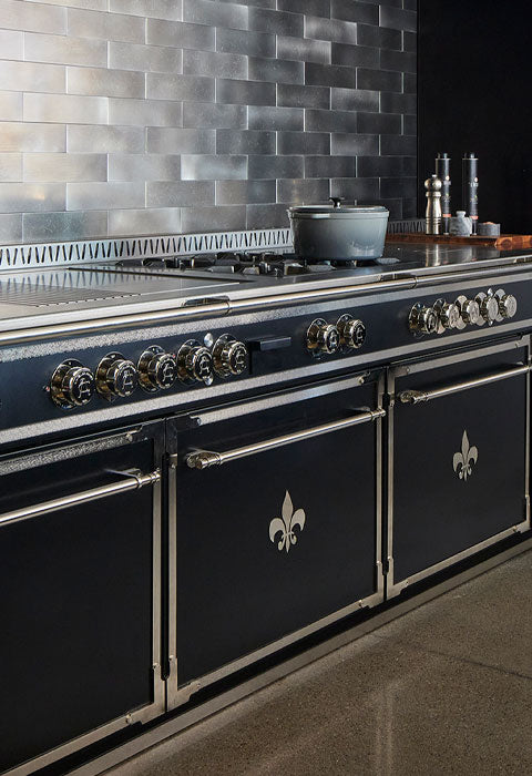 Matt Black Kitchen Cabinets With an Oven, Silver Handles & Burners and cookware on a gas stove