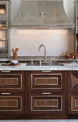 Wooden kitchen drawers with marble countertop and silver color hood
