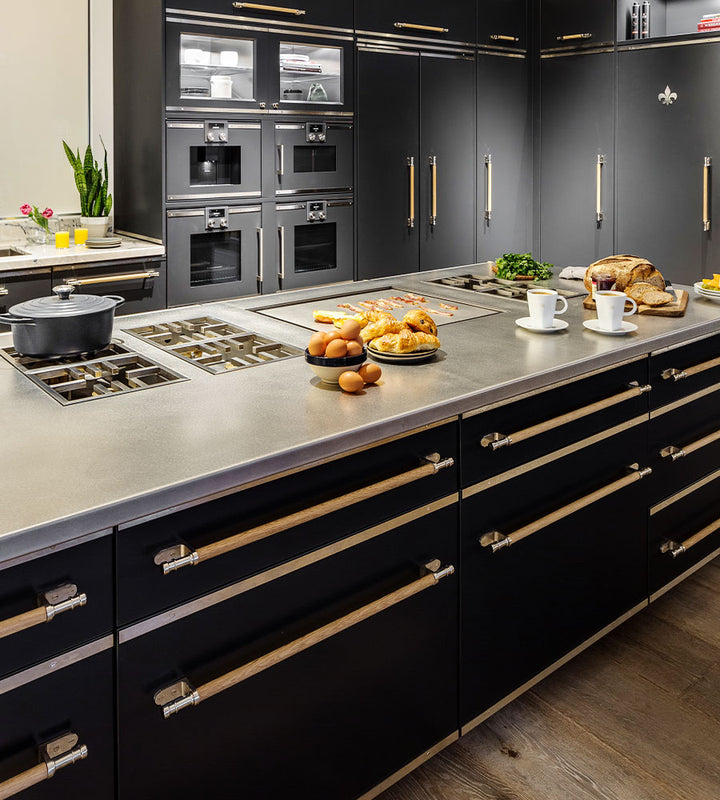 Black French kitchen ranges, drawers with wooden handles, black color cupboards and oven drawers