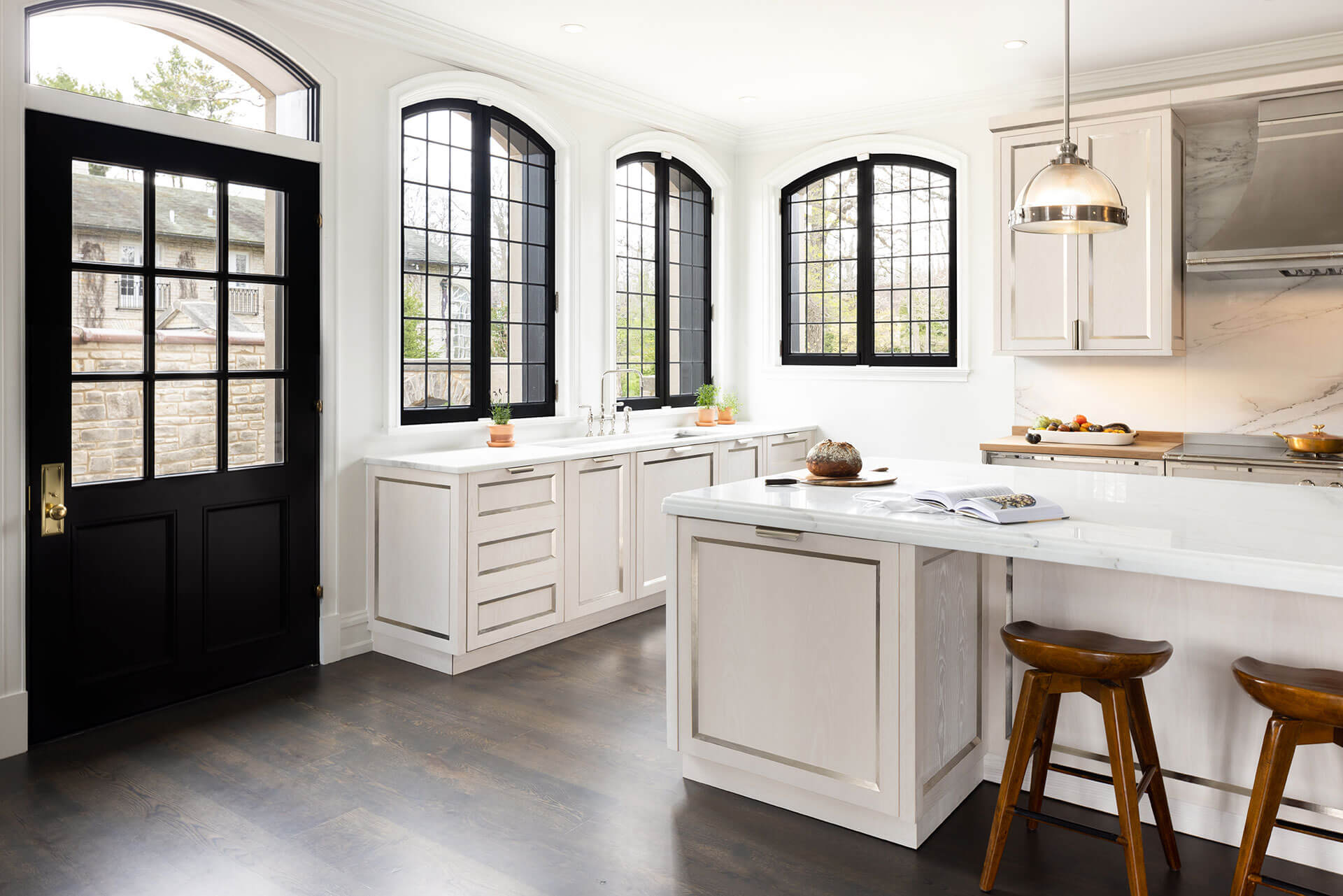 Customized kitchen with white luxury cabinets and white kitchen countertop nearby wooden stools